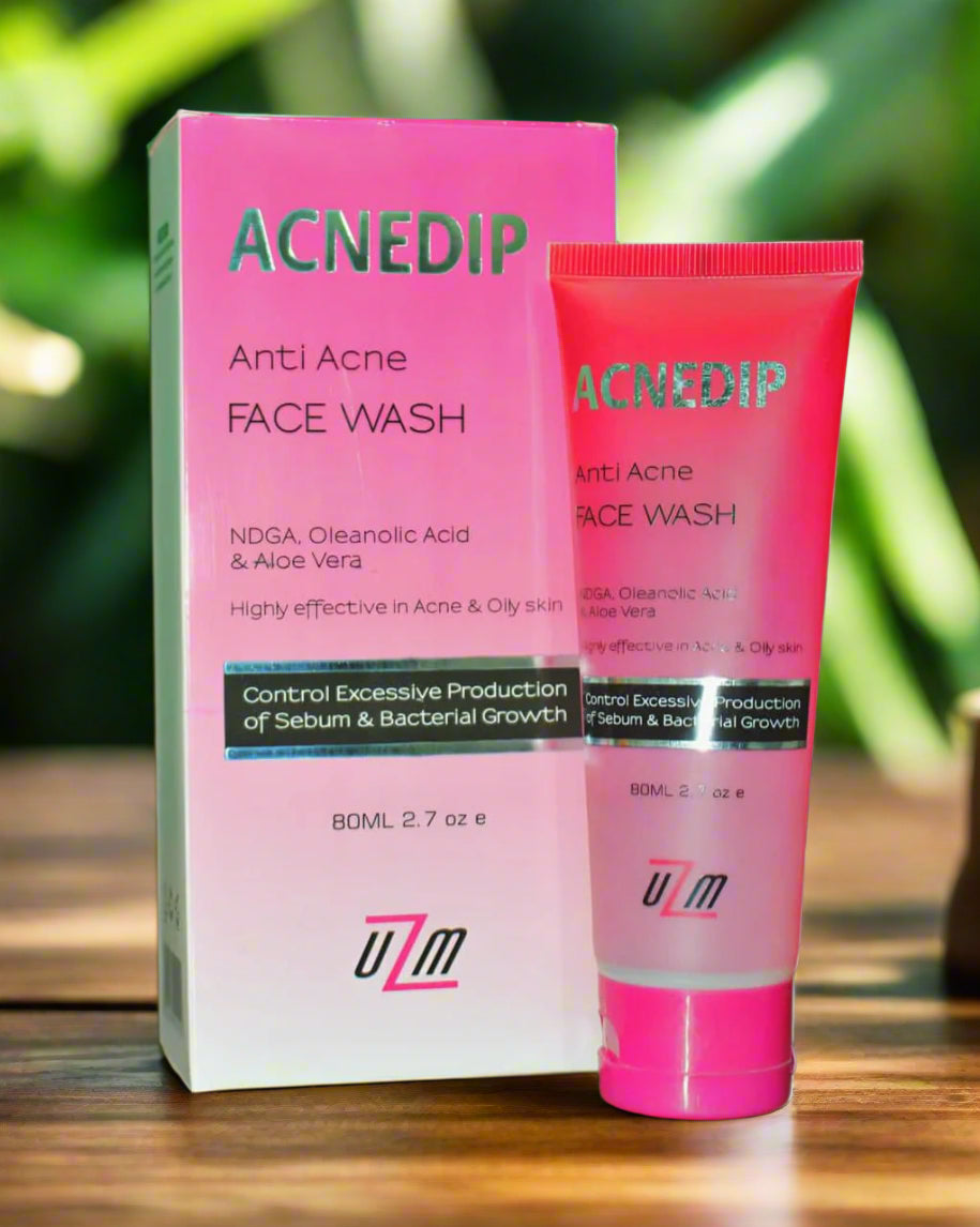 The image shows a package and tube of ACNEDIP Anti Acne Face Wash, with pink and white color scheme.