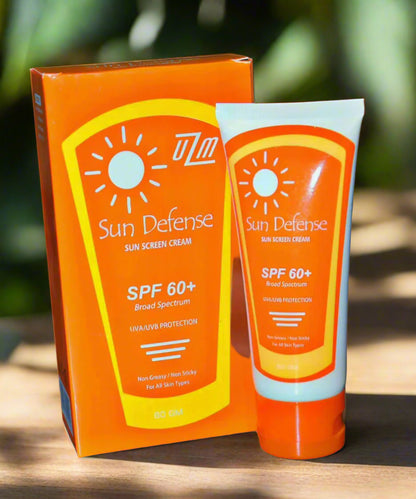 A tube of Sundefense sunscreen cream with SPF 60+ is displayed next to its packaging, which is also orange with sun protection messages.